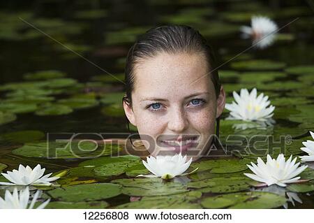 Young woman in water among the water lilies; Connecticut, United States of America View Large Photo Image Stock Photo - Young woman in water among the water lilies; Connecticut, United States of America. Fotosearch