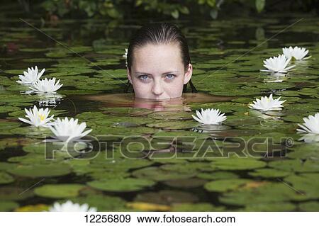 Young woman in water among the water lilies; Connecticut, United States of America View Large Photo Image Stock Photo - Young woman in water among the water lilies; Connecticut, United States of America. Fotosearch