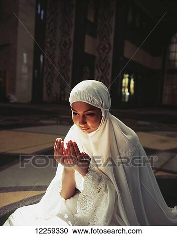 Young woman kneels in prayer in Brunei Mosque; Bandar Seri Begawan, Brunei View Large Photo Image Stock Image - Young woman kneels in prayer in Brunei Mosque; Bandar Seri Begawan, Brunei. Fotosearch