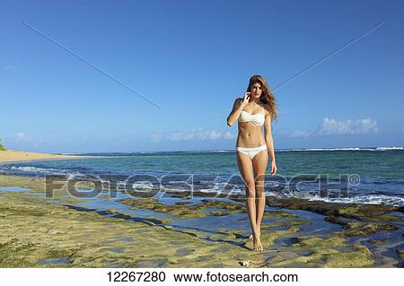 Young woman on the beach in a white bikini; Kauai, Hawaii, United States of America View Large Photo Image Stock Image - Young woman on the beach in a white bikini; Kauai, Hawaii, United States of America. Fotosearch