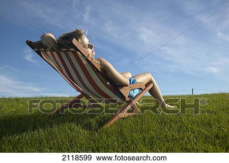Stock Photo - Young Woman Relaxing On Lounge Chair Outdoors In Summer; Toronto Ontario Canada. Fotosearch