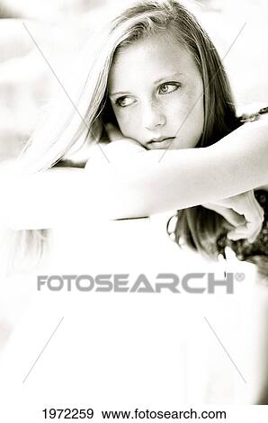 Young Woman Rests Her Head On Her Folded Arms. View Large Photo Image Stock Photo - Young Woman Rests Her Head On Her Folded Arms.. Fotosearch