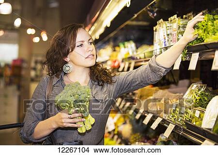 Picture - Young woman shopping in organic market for groceries; St. Albert, Alberta, Canada. Fotosearch