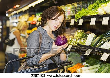 Stock Image - Young woman shopping in organic market for groceries; St. Albert, Alberta, Canada. Fotosearch