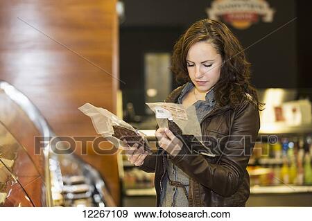 Stock Photo - Young woman shopping in organic market for her groceries; St. Albert, Alberta, Canada. Fotosearch
