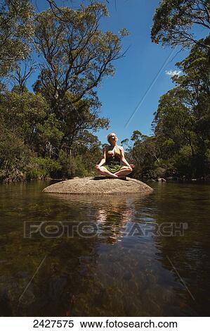 Young woman sitting in a creek doing yoga poses; Threadbo, New South Wales, Australia View Large Photo Image Stock Photography - Young woman sitting in a creek doing yoga poses; Threadbo, New South Wales, Australia. Fotosearch