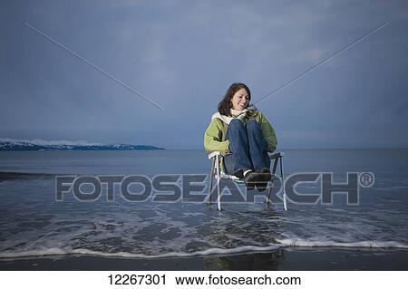 Young woman sitting in a lawn chair along the water's edge at twilight, Homer Spit, Kenai Peninsula, Southcentral Alaska View Large Photo Image Stock Image - Young woman sitting in a lawn chair along the water's edge at twilight, Homer Spit, Kenai Peninsula, Southcentral Alaska. Fotosearch