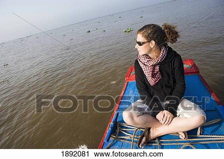 Stock Image - Young Woman Sitting On Boat In Mekong Delta. Fotosearch