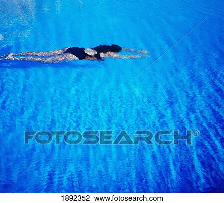 Stock Image - Young Woman Swimming In Tropical Water. Fotosearch