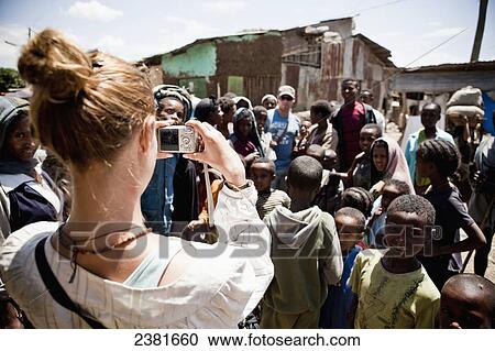 Young woman taking a picture of a group of interested children, Simien mountains; Ethiopia View Large Photo Image Stock Image - Young woman taking a picture of a group of interested children, Simien mountains; Ethiopia. Fotosearch