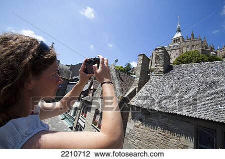 Young woman taking photos with Mont Saint Michel, Normandy, France View Large Photo Image Stock Image - Young woman taking photos with Mont Saint Michel, Normandy, France. Fotosearch