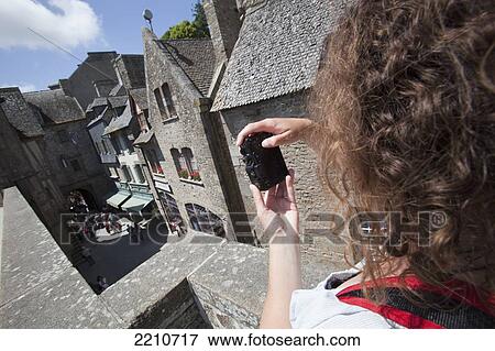 Young woman taking photos with Mont Saint Michel, Normandy, France View Large Photo Image Stock Photo - Young woman taking photos with Mont Saint Michel, Normandy, France. Fotosearch