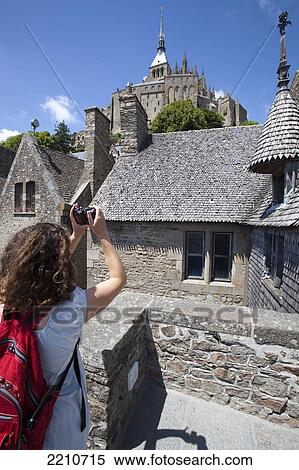 Stock Photography - Young woman taking photos with Mont Saint Michel, Normandy, France. Fotosearch
