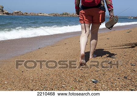 Young woman walking along beach in Northern Brittany, France View Large Photo Image Stock Photo - Young woman walking along beach in Northern Brittany, France. Fotosearch