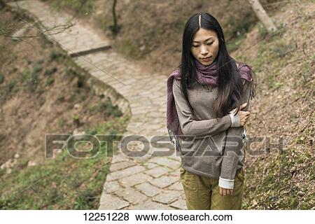 Stock Photo - Young woman walking on a trail; Xiamen, China. Fotosearch