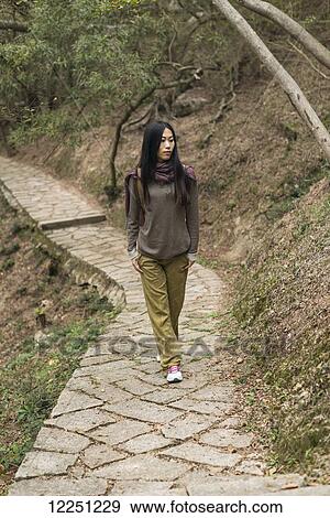 Young woman walking on a trail; Xiamen, China View Large Photo Image Stock Photo - Young woman walking on a trail; Xiamen, China. Fotosearch