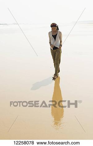 Stock Photo - Young woman walking on the beach from HuoHu, North of Kinsmen Island; HuoHu, Taiwan. Fotosearch