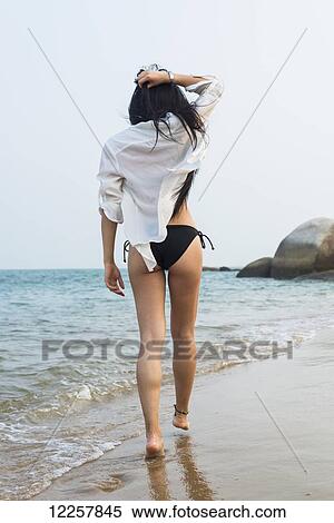 Young woman walking on the beach in a bikini; Xiamen, China View Large Photo Image Stock Photography - Young woman walking on the beach in a bikini; Xiamen, China. Fotosearch