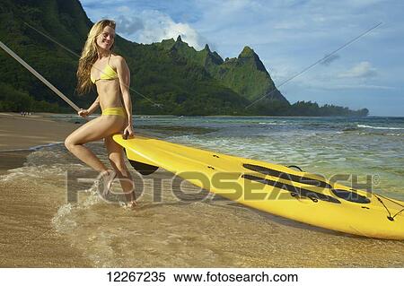 Young woman with stand up paddle board; Kauai, Hawaii, United States of America View Large Photo Image Stock Photography - Young woman with stand up paddle board; Kauai, Hawaii, United States of America. Fotosearch