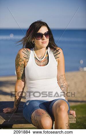 Picture - Young Woman With Tattoos Sitting By Lake Simcoe; Ontario Canada. Fotosearch