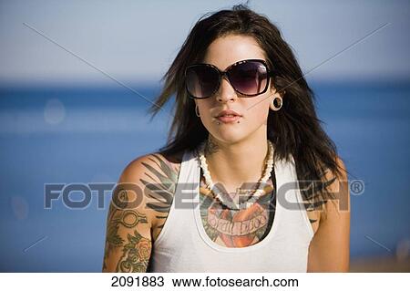 Stock Image - Young Woman With Tattoos Sitting By Lake Simcoe; Ontario Canada. Fotosearch