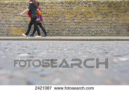 Young women walking beside a brick building along Portobello Road; London, England View Large Photo Image Stock Photo - Young women walking beside a brick building along Portobello Road; London, England. Fotosearch