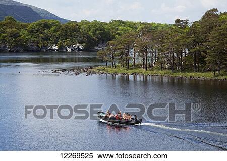 Stock Photography - A boat of tourists on the Lakes of Killarney; Killarney, County Kerry, Ireland. Fotosearch