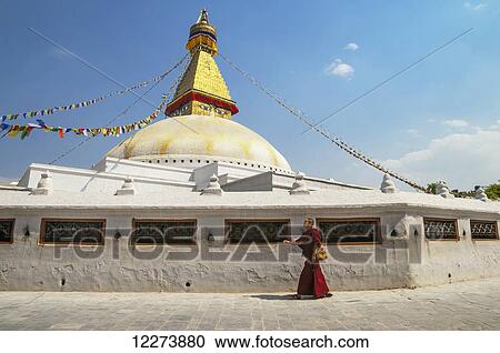 Stock Image - A buddhist monk walking around of Boudhanath Stupa; Kathmandu, Nepal. Fotosearch