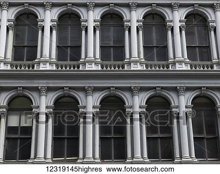 Stock Photograph - A building's facade with white pillars and arched windows; New York City, New York, United States of America. Fotosearch