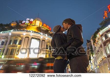 A couple kissing with the blur of traffic and pedestrians in the background; Hong Kong, China View Large Photo Image Stock Image - A couple kissing with the blur of traffic and pedestrians in the background; Hong Kong, China. Fotosearch