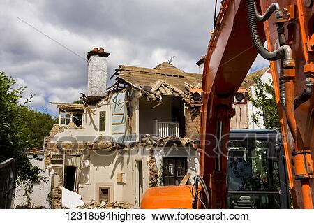 Stock Photograph - A digger does demolition at a construction site; Kingston on Thames, Surrey, England. Fotosearch