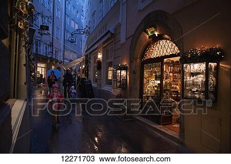 A family strolls past an antique shop in the pedestrianised streets of the old city on a rainy day; Salzburg, Austria View Large Photo Image Stock Image - A family strolls past an antique shop in the pedestrianised streets of the old city on a rainy day; Salzburg, Austria. Fotosearch