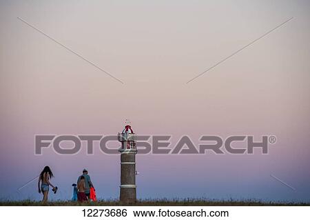 A family walks at sunset with a view of the top of the lighthouse; Cabo Polonio, Uruguay View Large Photo Image Stock Photograph - A family walks at sunset with a view of the top of the lighthouse; Cabo Polonio, Uruguay. Fotosearch