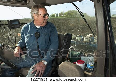 A farmer carefully monitors grain corn planting operations from the cab of his tractor, guided by a GPS guidance system, near Northrop; Minnesota, United States of America View Large Photo Image Stock Image - A farmer carefully monitors grain corn planting operations from the cab of his tractor, guided by a GPS guidance system, near Northrop; Minnesota, United States of America. Fotosearch