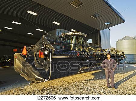 A farmer next to his combine parked in front of the farm repair shop, near Lorette; Manitoba, Canada View Large Photo Image Stock Photograph - A farmer next to his combine parked in front of the farm repair shop, near Lorette; Manitoba, Canada . Fotosearch
