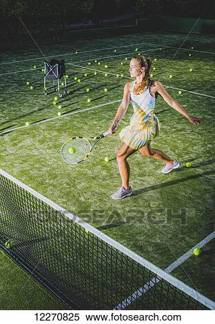 A girl on a tennis court with a racquet and numerous tennis balls; Tarifa, Cadiz, Andalusia, Spain View Large Photo Image Stock Photography - A girl on a tennis court with a racquet and numerous tennis balls; Tarifa, Cadiz, Andalusia, Spain. Fotosearch