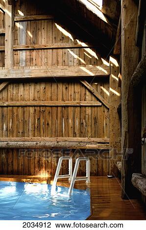 Stock Image - A Ladder In A Pool Inside A Barn, Montreal, Quebec. Fotosearch