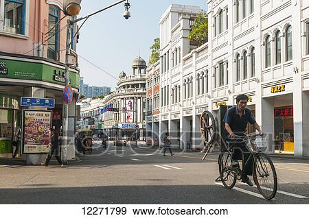 Stock Photo - A man carries a cart on his bicycle in Xiamen's downtown; Xiamen, Fujian Province, China. Fotosearch