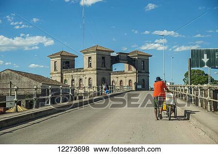 A man pushes his bicycle up the road in Jaguarao, border between Brazil and Uruguay; Jaguarao, Brazil View Large Photo Image Stock Photo - A man pushes his bicycle up the road in Jaguarao, border between Brazil and Uruguay; Jaguarao, Brazil. Fotosearch