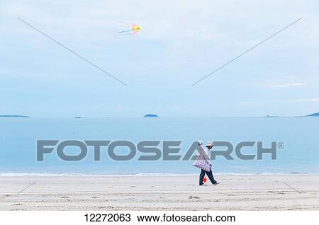 Stock Image - A man selling kites along the beach; Xiamen, Fujian Province, China. Fotosearch