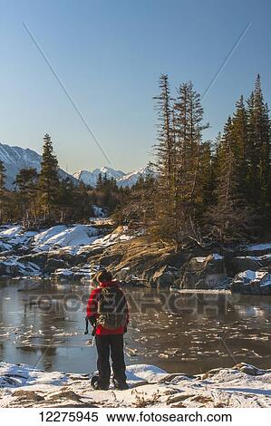 Stock Photography - A man snowshoeing along the Cook Inlet with Kenai Mountains in the background, Southcentral Alaska, Winter. Fotosearch