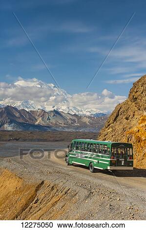 Stock Image - A park bus on the park road with Mount Mckinley in the background, Denali National Park, Alaska, Summer. Fotosearch