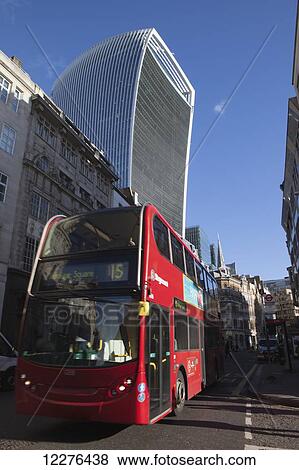 A red London double-decker bus passes in front of the Walkie Talkie building, 20 Fenchurch Street, designed by Rafael Vinoly; London, England View Large Photo Image Stock Photo - A red London double-decker bus passes in front of the Walkie Talkie building, 20 Fenchurch Street, designed by Rafael Vinoly; London, England. Fotosearch