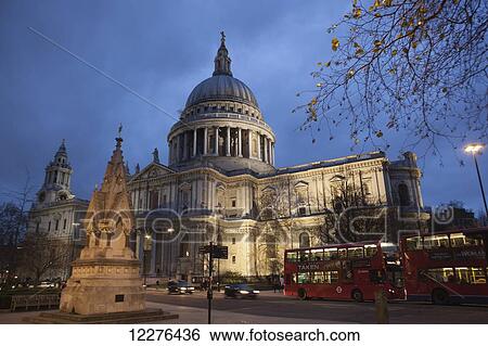 Stock Photograph - A red London Route Master double-decker bus passes St Paul's Cathedral at dusk, with the St Lawrence Jewry Memorial Fountain in the foreground; London, England. Fotosearch