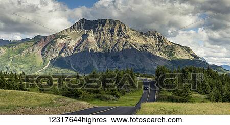 Stock Photograph - A road travels through Waterton Lakes National Park; Alberta, Canada. Fotosearch