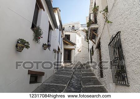 A sloped street between houses in Pampaneira, one of the most famous villages in Alpujarra; Granada Province, Andalucia, Spain View Large Photo Image Stock Photograph - A sloped street between houses in Pampaneira, one of the most famous villages in Alpujarra; Granada Province, Andalucia, Spain. Fotosearch