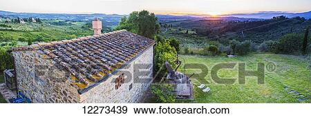 Stock Photo - A stone house and a view of the lush landscape at sunset, Villa Capanuccia; Florence, Italy. Fotosearch