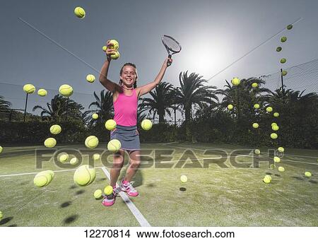 Picture - A teenage girl on a tennis court with a racquet and numerous tennis balls; Tarifa, Cadiz, Andalusia, Spain. Fotosearch