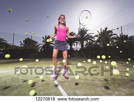 A teenage girl on a tennis court with a racquet and numerous tennis balls; Tarifa, Cadiz, Andalusia, Spain View Large Photo Image Stock Photo - A teenage girl on a tennis court with a racquet and numerous tennis balls; Tarifa, Cadiz, Andalusia, Spain. Fotosearch