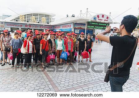 Stock Photo - A tour group posing for a picture on Gulangyu Island; Xiamen, Fujian province, China. Fotosearch